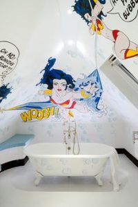 White bathroom with superheroes muralled onto the walls
