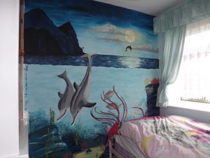 Girls underwater mural with dolphins