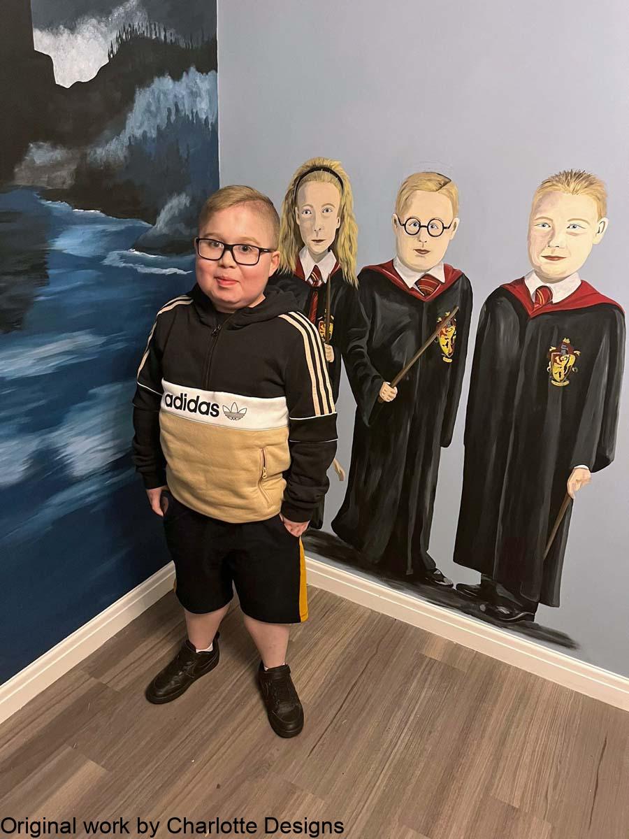charlie and room Boy standing in front his mural of him dressed as Harry Potter