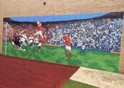 Outside hand painted football themed mural for hospital courtyard