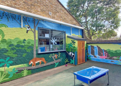 Jungle themed playground mural in greens and blues