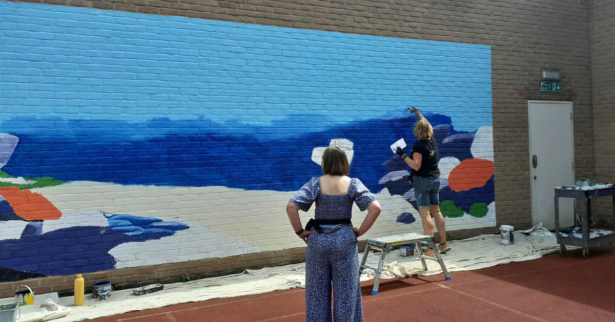me painting Meadow Football mural for mental health hospital