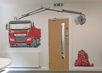 Red grabber truck holding red mug with pile of mugs. Hand painted mural in business kitchen